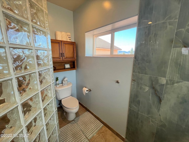 bathroom with tile patterned floors, baseboards, toilet, and walk in shower