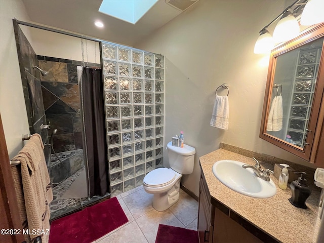 bathroom featuring tile patterned floors, a shower stall, a skylight, and vanity