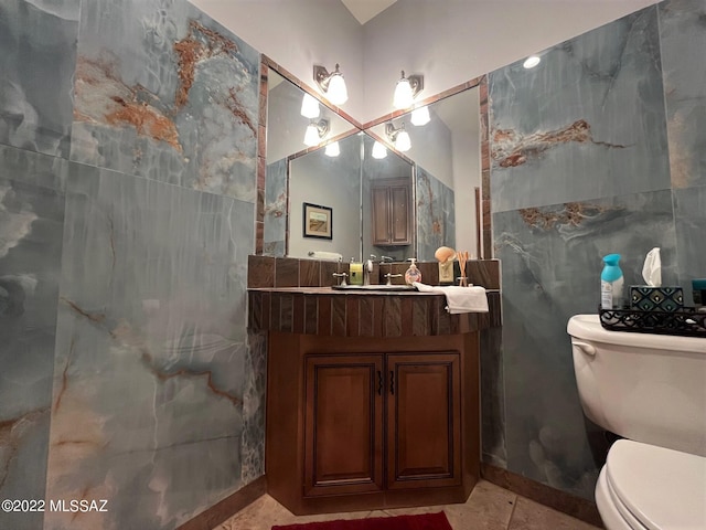 bathroom with vanity, tile patterned floors, toilet, and tile walls