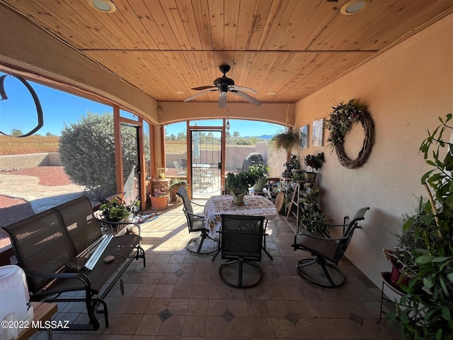 unfurnished sunroom with wood ceiling and ceiling fan