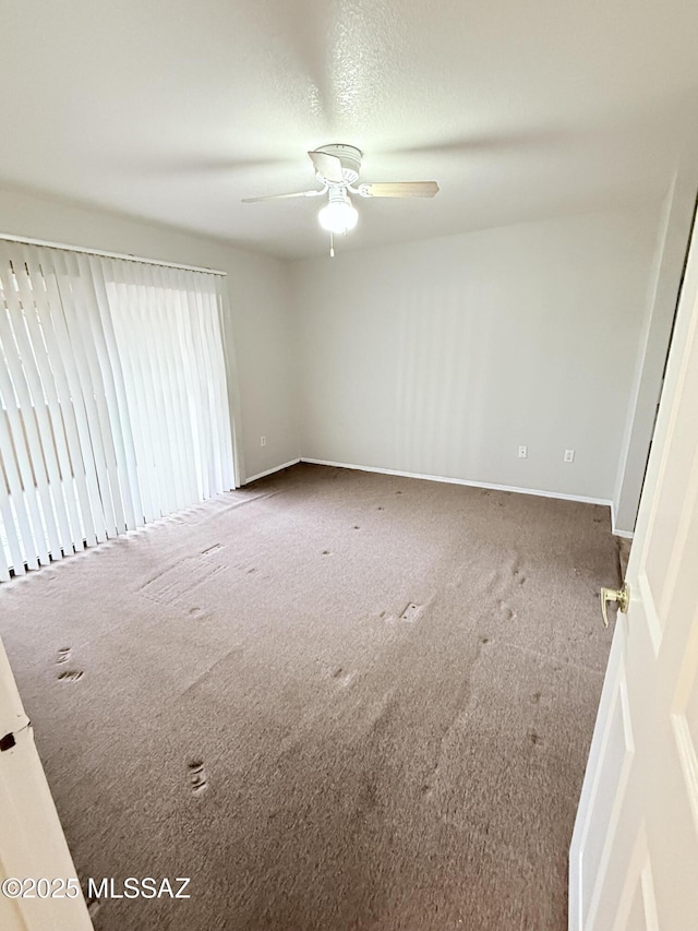 spare room featuring a textured ceiling, carpet, and ceiling fan