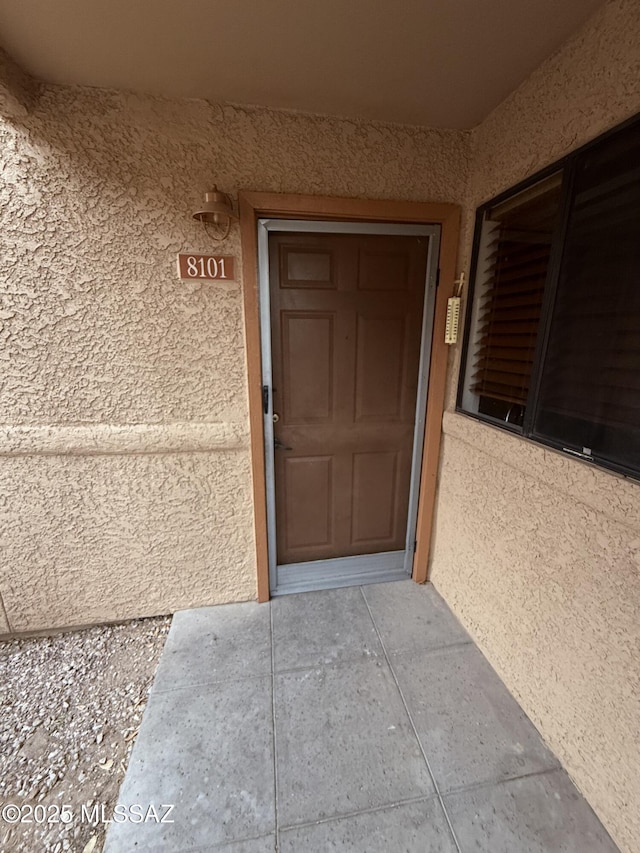 doorway to property featuring stucco siding