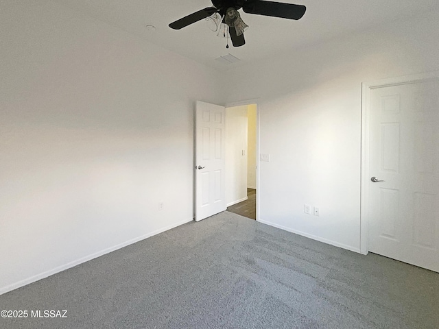 unfurnished bedroom featuring dark colored carpet, baseboards, and a ceiling fan