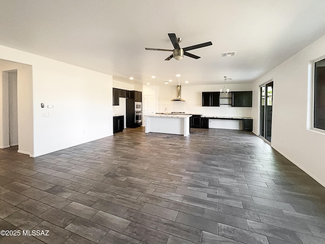 unfurnished living room with visible vents, recessed lighting, ceiling fan, and a sink