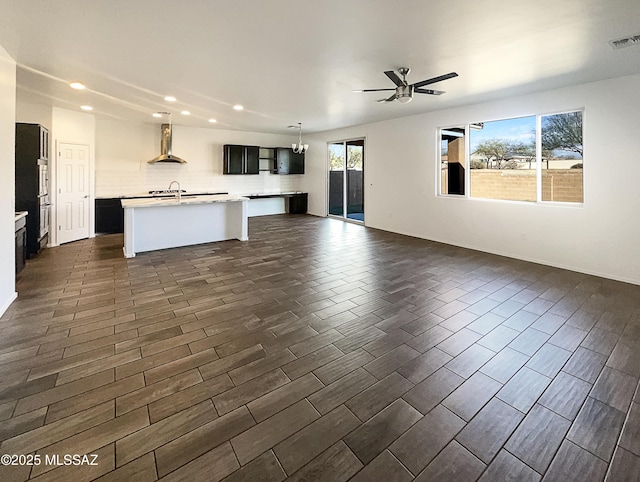 unfurnished living room featuring dark wood-style floors, visible vents, recessed lighting, and a ceiling fan