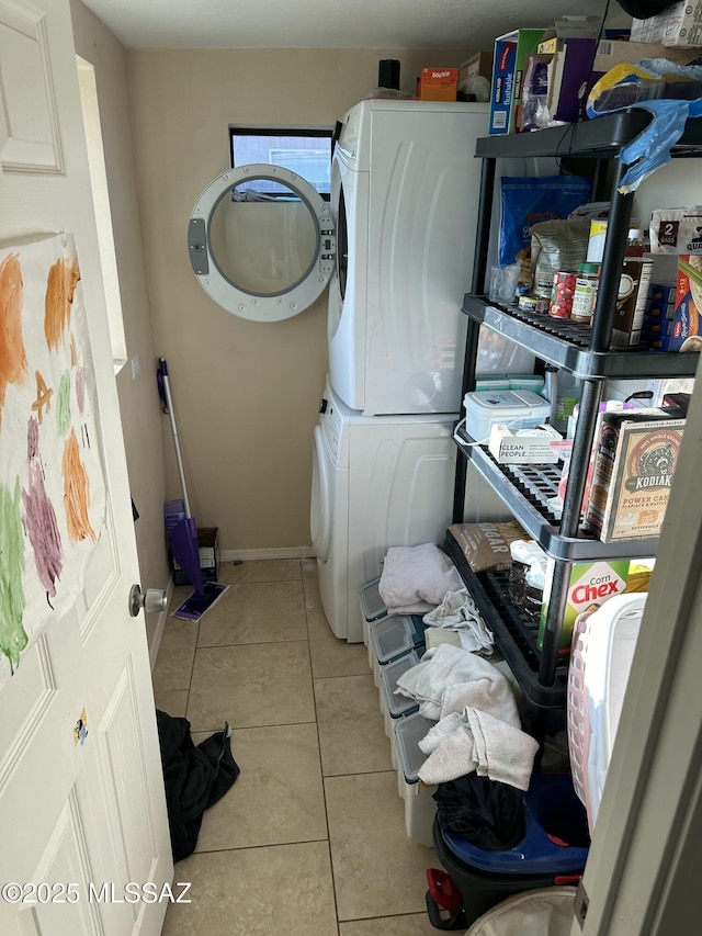 laundry area featuring tile patterned flooring, laundry area, and stacked washer / drying machine