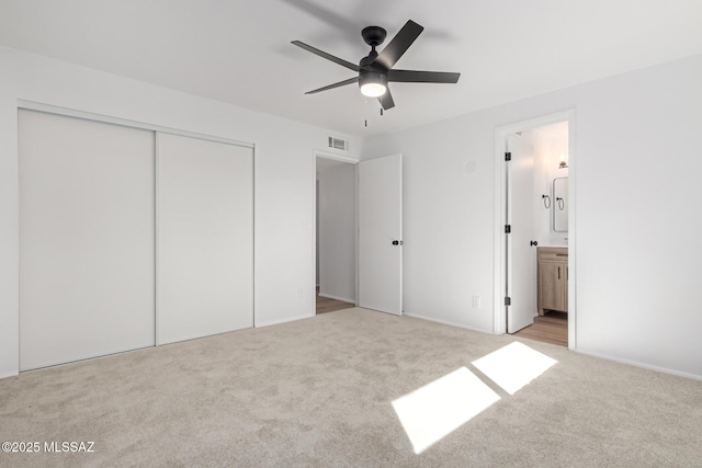 unfurnished bedroom with visible vents, a ceiling fan, ensuite bathroom, a closet, and carpet floors