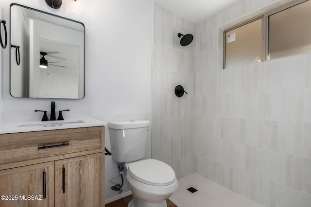 full bath featuring a tile shower, toilet, and vanity