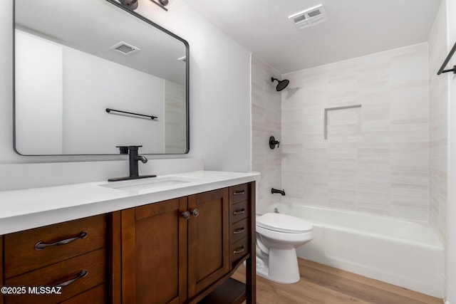 bathroom with vanity, toilet, wood finished floors, and visible vents