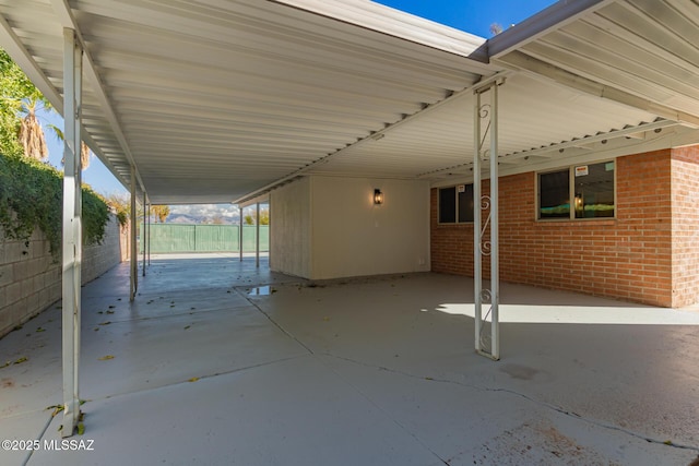 view of patio with an attached carport and fence