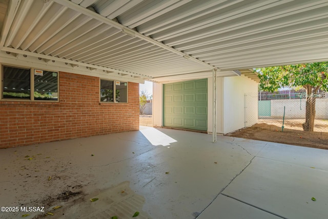 view of patio featuring fence and a garage