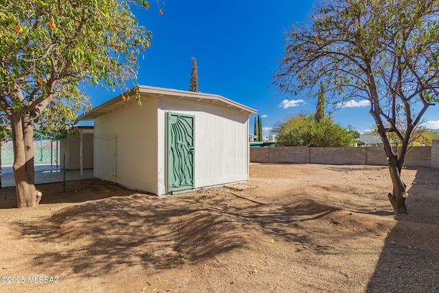 view of shed featuring fence