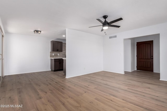 unfurnished living room with visible vents, a ceiling fan, and light wood-style floors