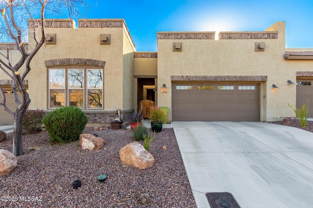 view of front of house with stucco siding and concrete driveway