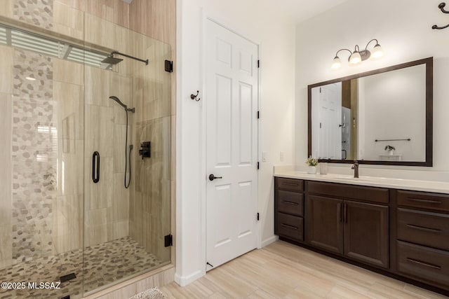 full bath featuring wood finished floors, vanity, and a shower stall