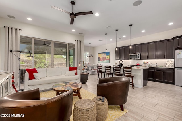 living room with a ceiling fan, recessed lighting, and visible vents