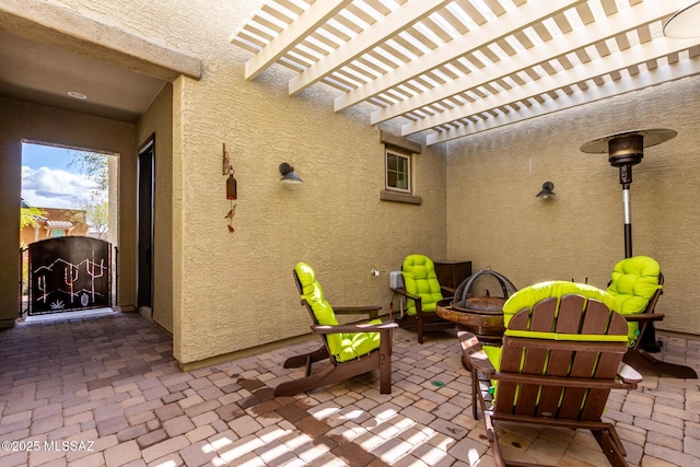 view of patio with a gate, a fire pit, and a pergola