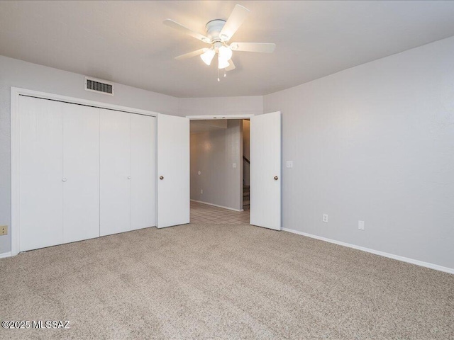 unfurnished bedroom featuring visible vents, a ceiling fan, a closet, carpet flooring, and baseboards