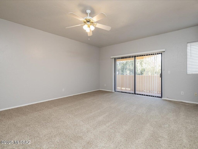 carpeted spare room with baseboards and a ceiling fan