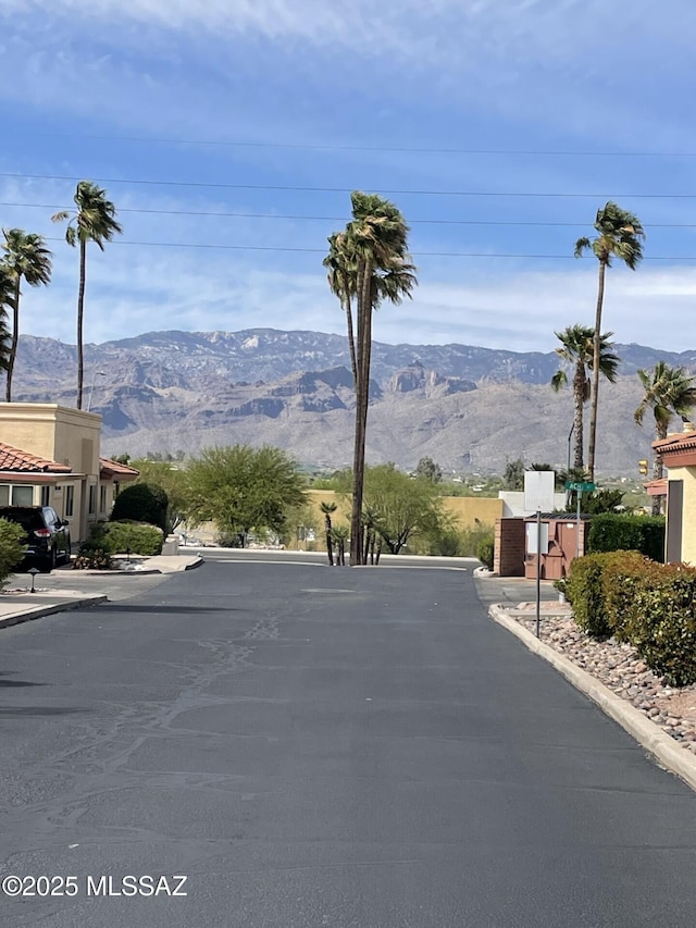 view of road featuring a mountain view and curbs