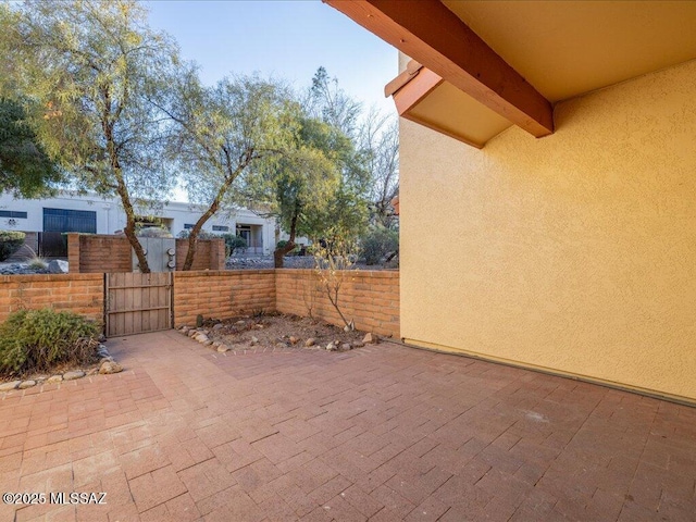 view of patio featuring a gate and fence