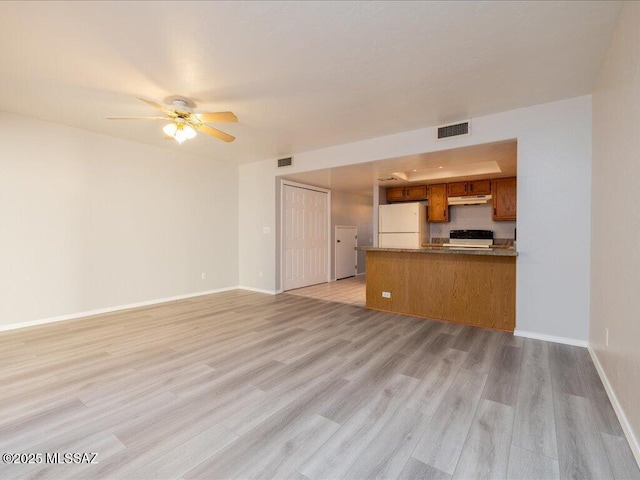 unfurnished living room with visible vents, ceiling fan, light wood-type flooring, and baseboards