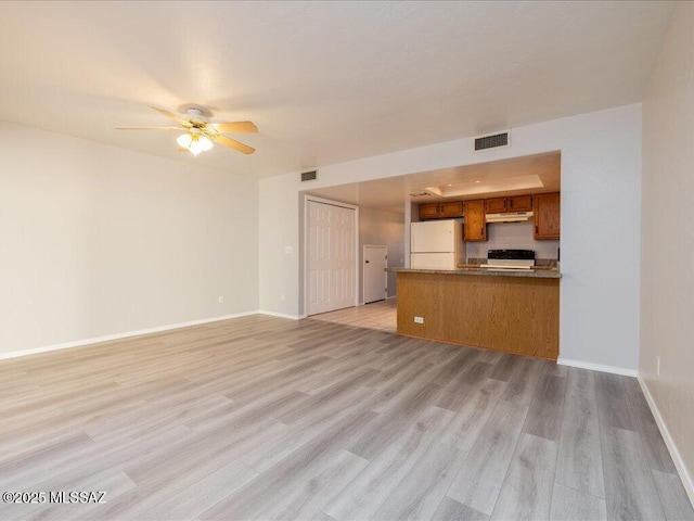 unfurnished living room featuring light wood-type flooring, visible vents, baseboards, and ceiling fan