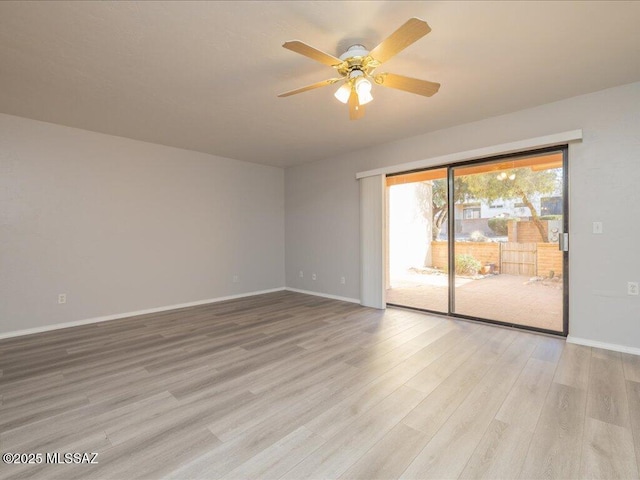 spare room featuring ceiling fan, baseboards, and light wood finished floors