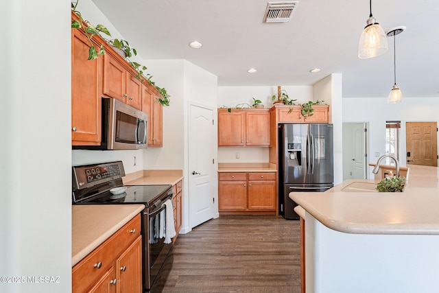 kitchen featuring visible vents, a sink, dark wood finished floors, appliances with stainless steel finishes, and light countertops