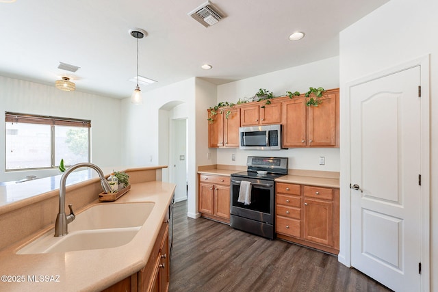 kitchen with visible vents, brown cabinets, stainless steel appliances, and a sink