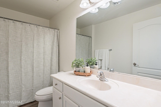 bathroom featuring visible vents, toilet, and vanity