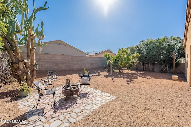 view of yard featuring a fenced backyard, a fire pit, and a patio