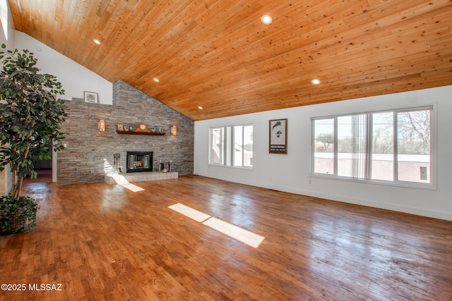 unfurnished living room featuring a stone fireplace, wood ceiling, wood finished floors, and high vaulted ceiling