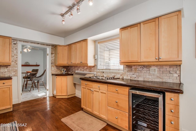 kitchen with wine cooler, light brown cabinets, and dark countertops