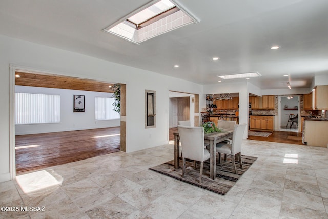 dining area featuring recessed lighting, baseboards, and a skylight