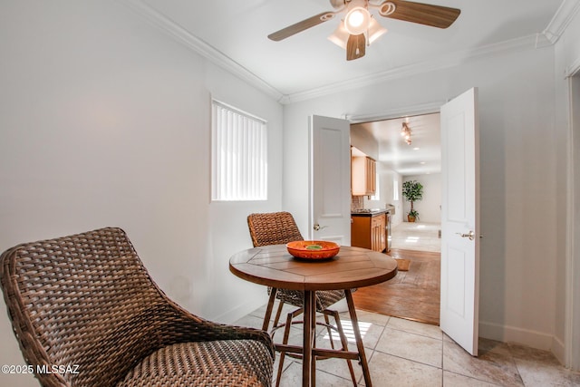 living area featuring light tile patterned floors, a ceiling fan, crown molding, and baseboards