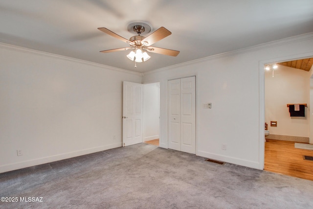 unfurnished bedroom featuring attic access, baseboards, crown molding, and carpet