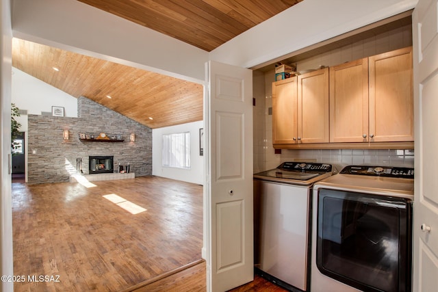 laundry room with wooden ceiling, a fireplace, wood finished floors, cabinet space, and independent washer and dryer