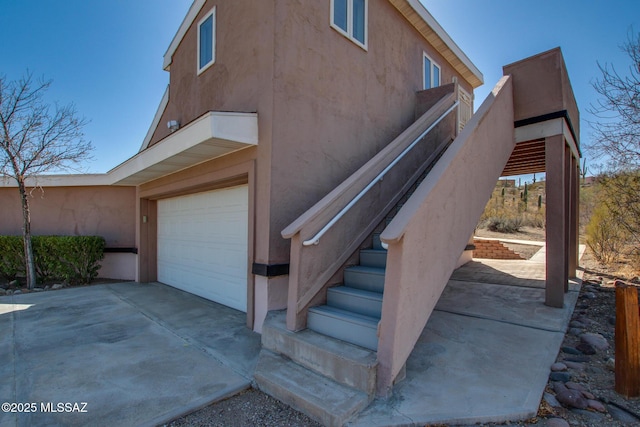 exterior space with a garage, driveway, and stucco siding