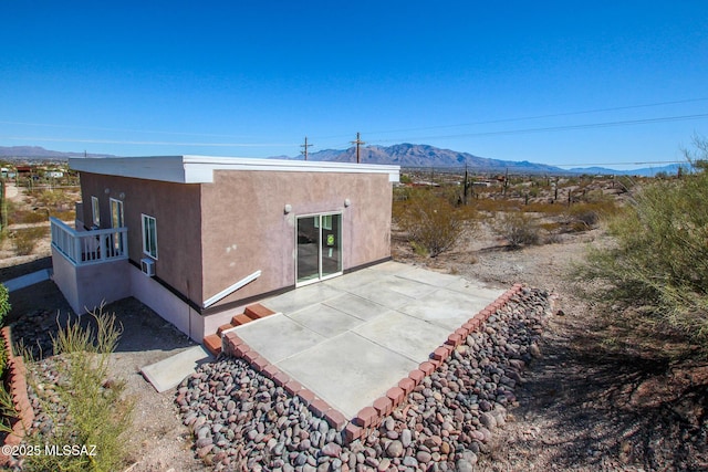 rear view of property featuring a patio area, stucco siding, and a mountain view