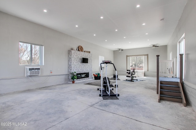 exercise area with a glass covered fireplace, a ceiling fan, recessed lighting, and a wall mounted AC