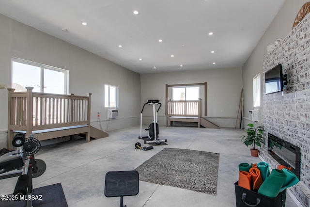 exercise area with a glass covered fireplace, recessed lighting, and a wall mounted AC