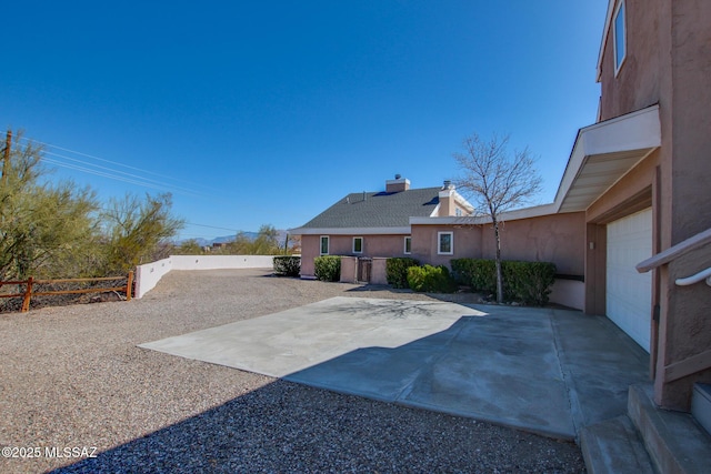 view of yard featuring a patio, a garage, and fence