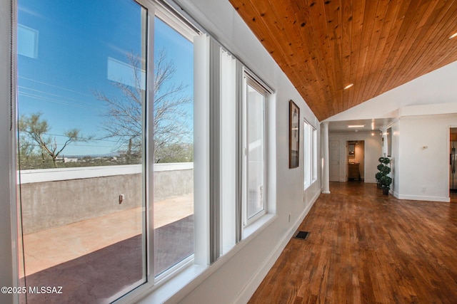 hall with visible vents, lofted ceiling, wood finished floors, baseboards, and wood ceiling