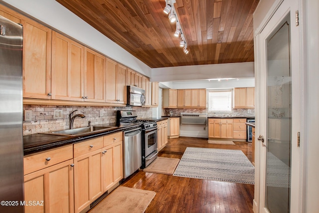 kitchen featuring light brown cabinetry, a sink, dark countertops, stainless steel appliances, and wooden ceiling