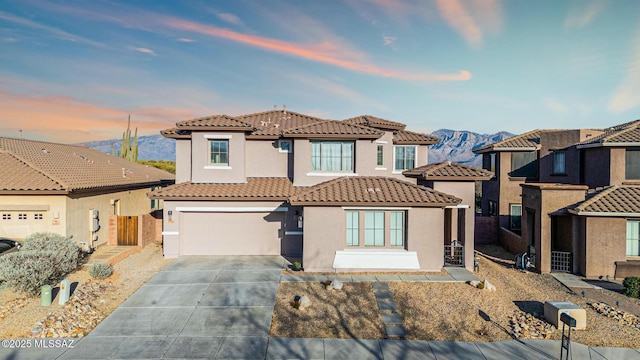 view of front of house with fence, an attached garage, stucco siding, concrete driveway, and a tiled roof