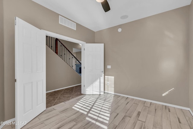 unfurnished room featuring visible vents, baseboards, ceiling fan, and wood finished floors