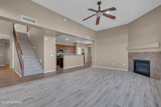 unfurnished living room featuring ceiling fan, baseboards, visible vents, and light wood-type flooring