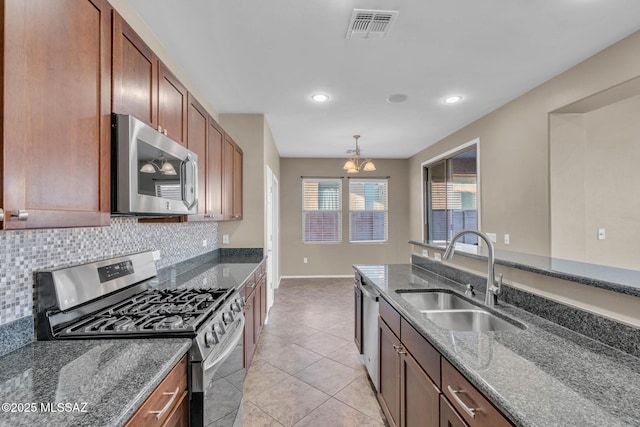 kitchen with visible vents, decorative backsplash, a notable chandelier, stainless steel appliances, and a sink