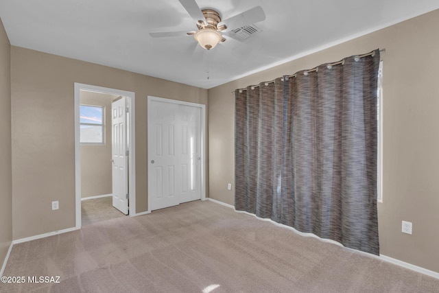 unfurnished bedroom featuring a ceiling fan, carpet, visible vents, and baseboards